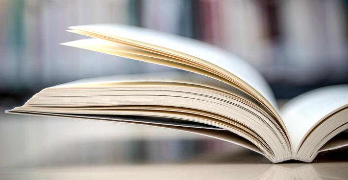 A book lying open on a table out of focus